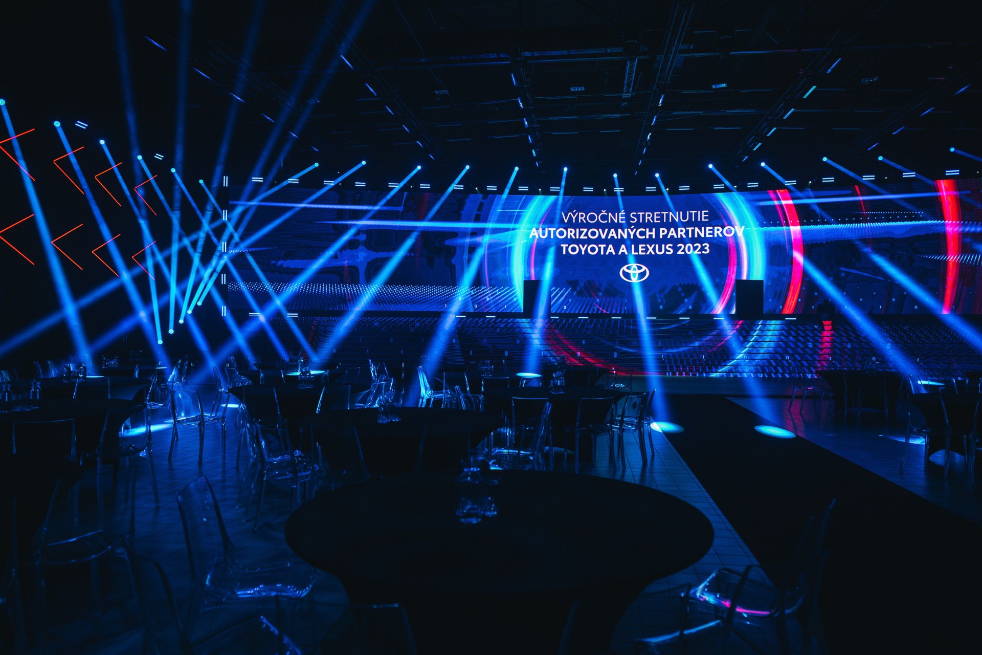 Large corporate event stage produced with broadcast lighting and video screens